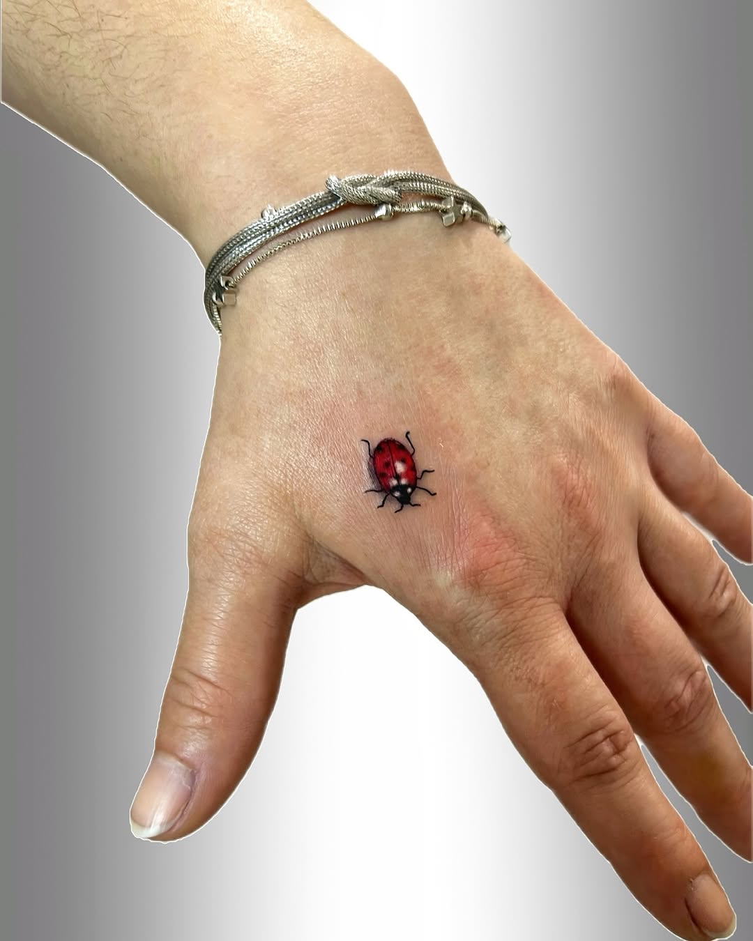 Charming ladybug tattoo on the hand