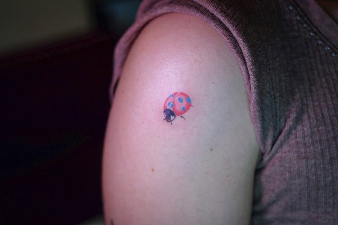 Charming ladybug tattoo on the upper arm