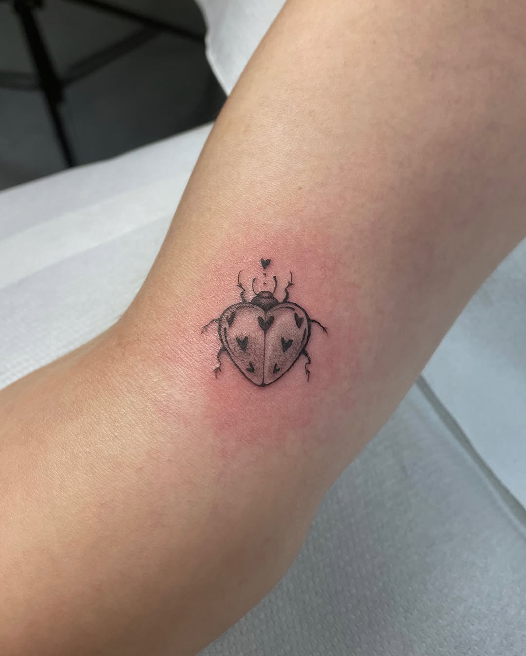 Charming heart-shaped ladybug tattoo design
