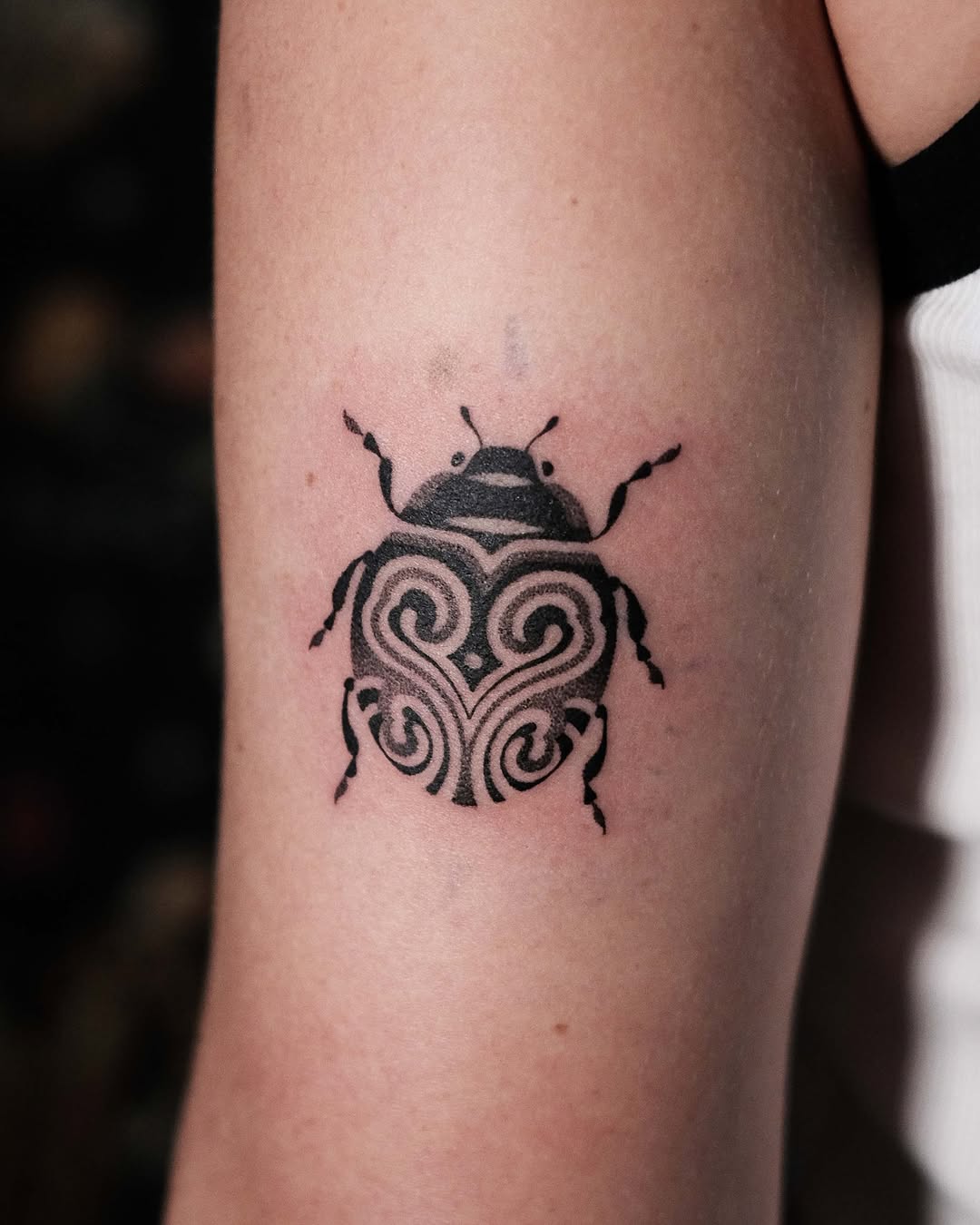 Elegant tribal ladybug tattoo in black ink