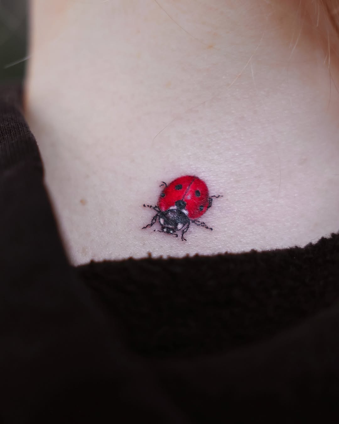 Charming small ladybug tattoo on the neck