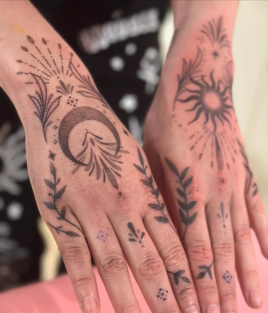 Elegant sun and moon hand tattoos with floral details