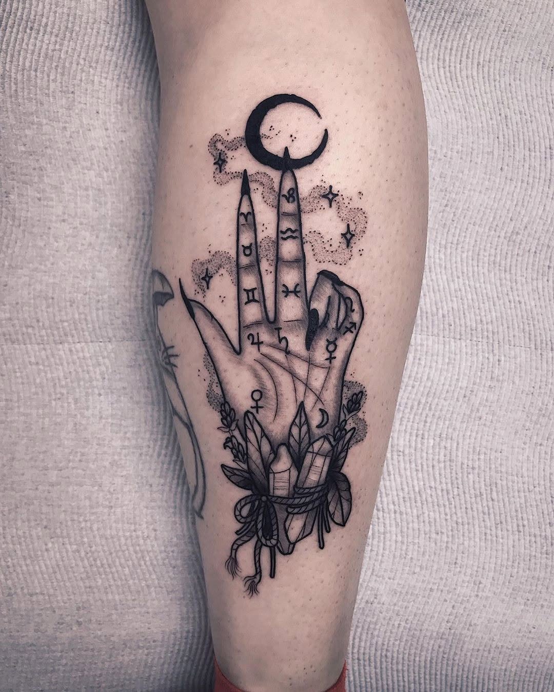 Mystical hand tattoo with celestial elements