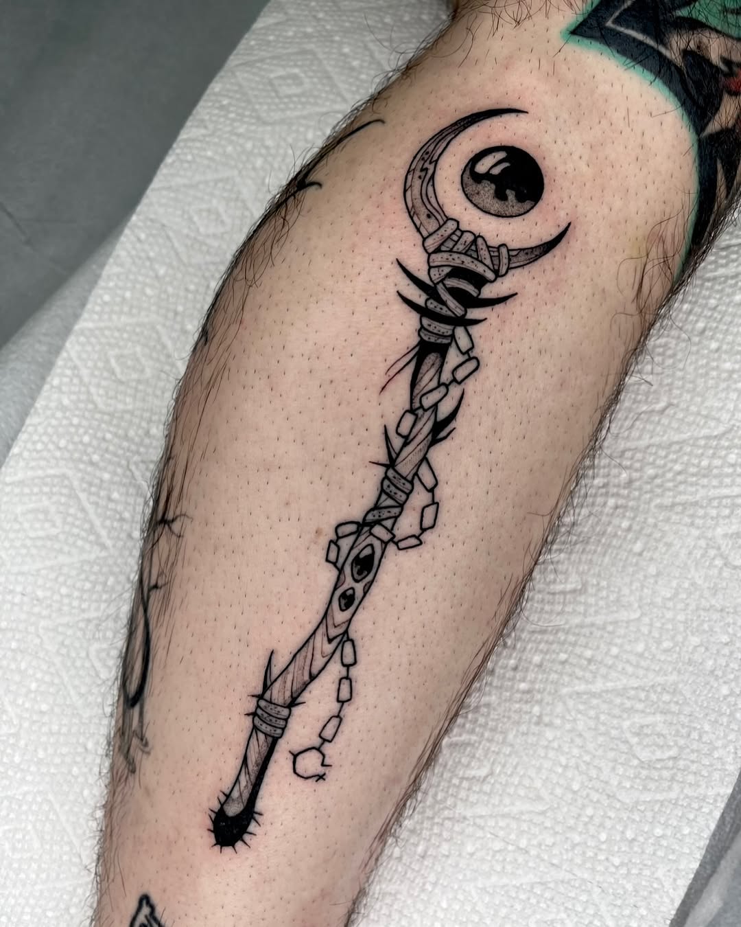Enchanting staff tattoo with mystical elements