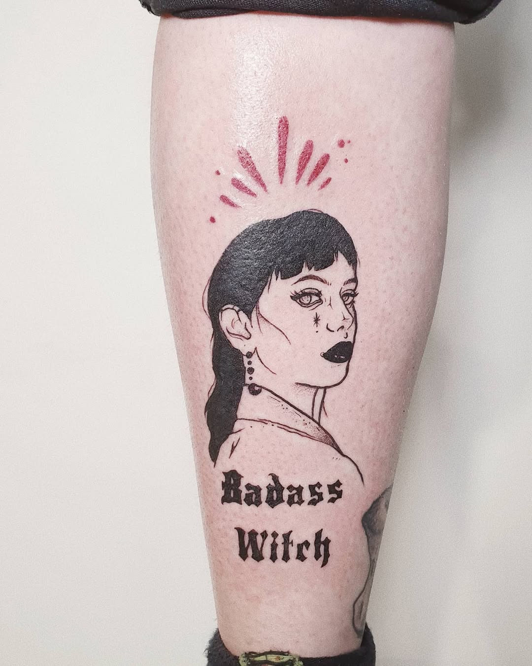 Empowered witch tattoo with striking portrait.