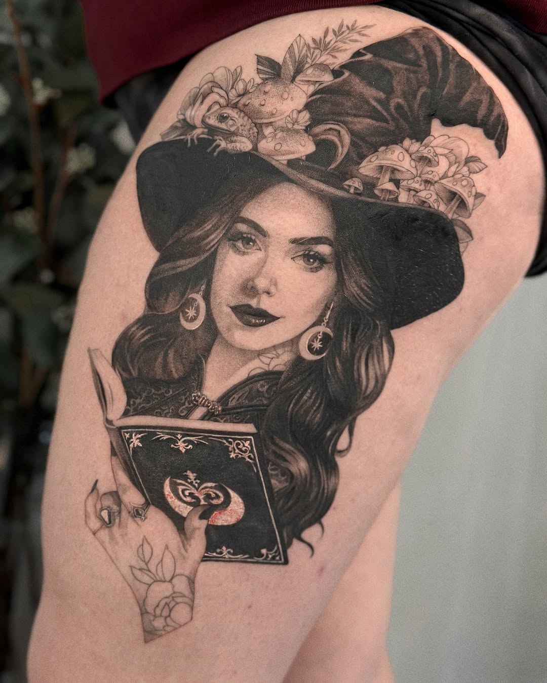 Enchanting witch with a mystical book tattoo