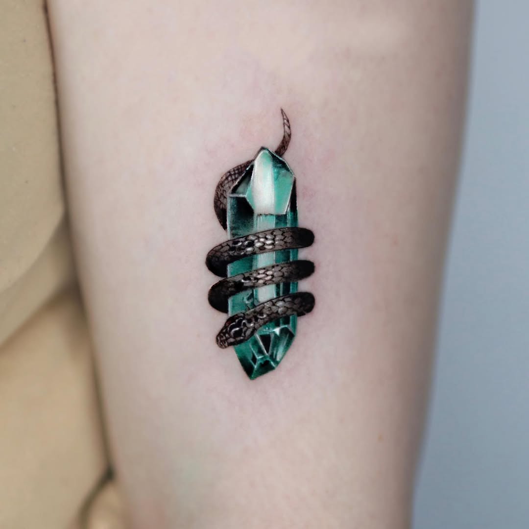 Intricate snake entwined around mystic crystal tattoo