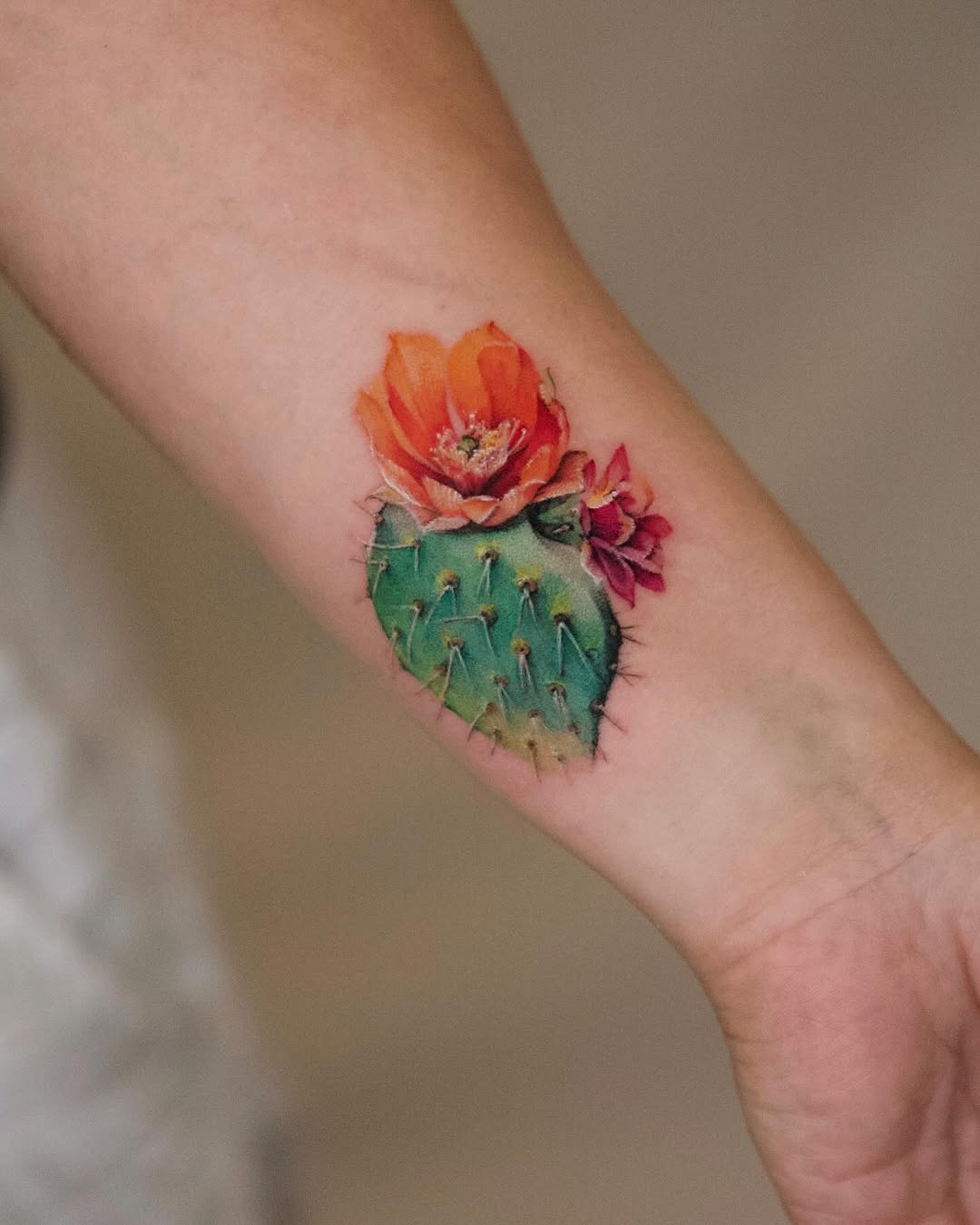 Stylish cactus tattoo with vibrant flower