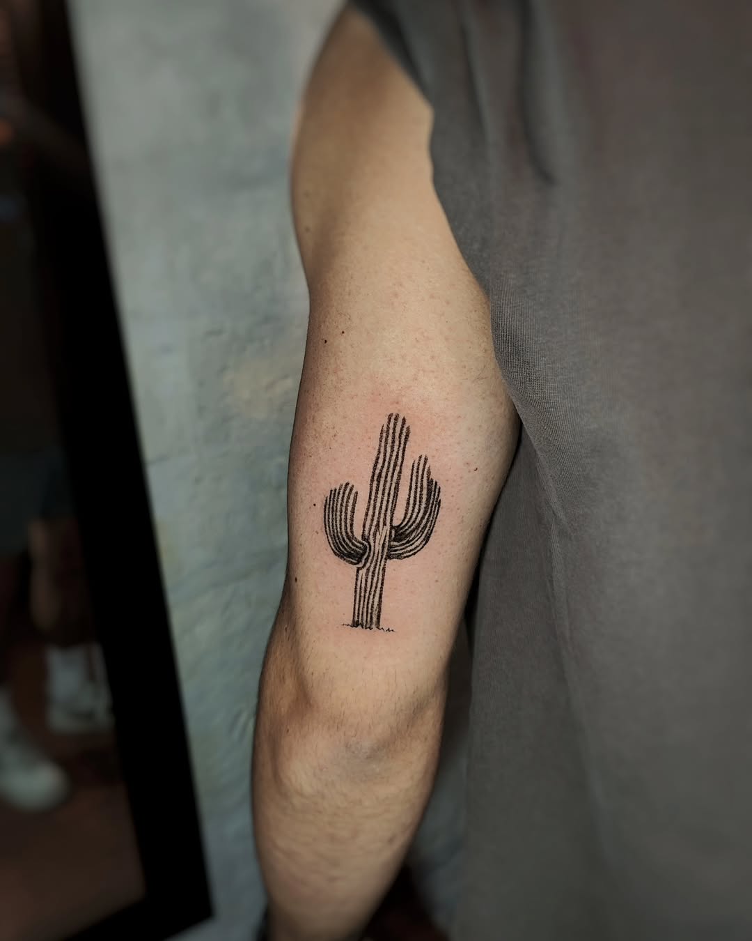 Minimalist cactus tattoo on arm