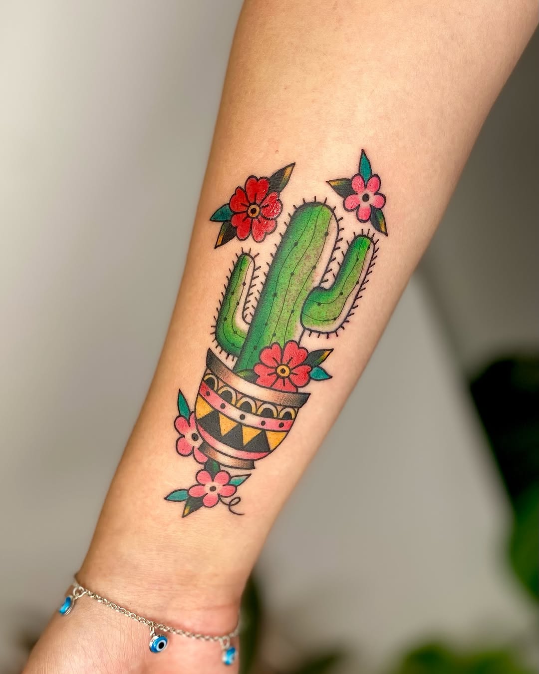 Vibrant cactus tattoo with floral details
