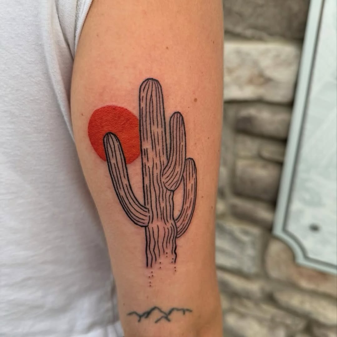 Minimalist cactus tattoo with vibrant sunset