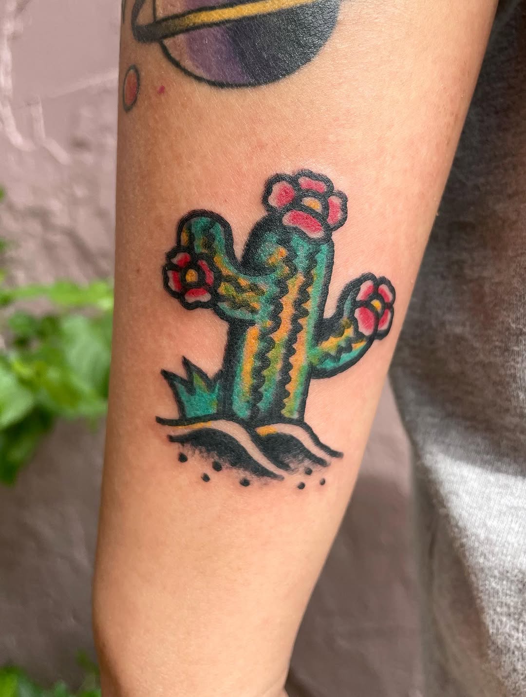 Vibrant cactus tattoo with floral accents