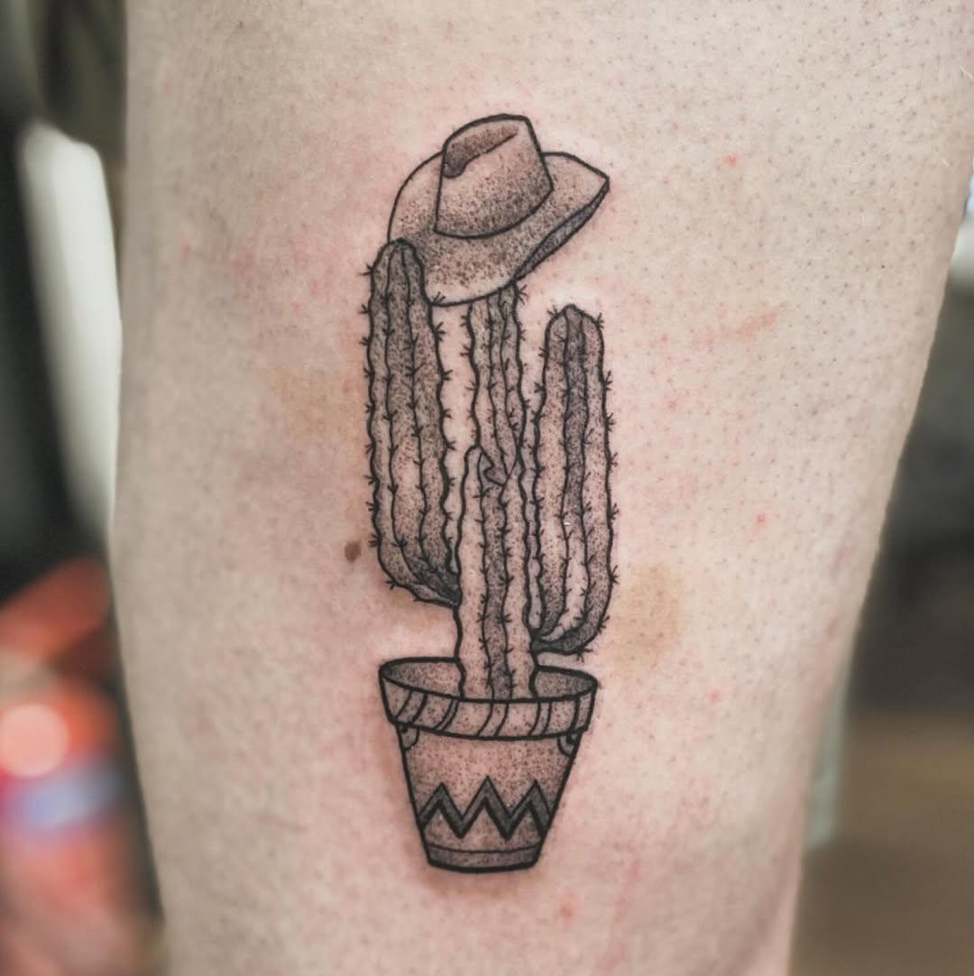Quirky cactus tattoo with a playful hat