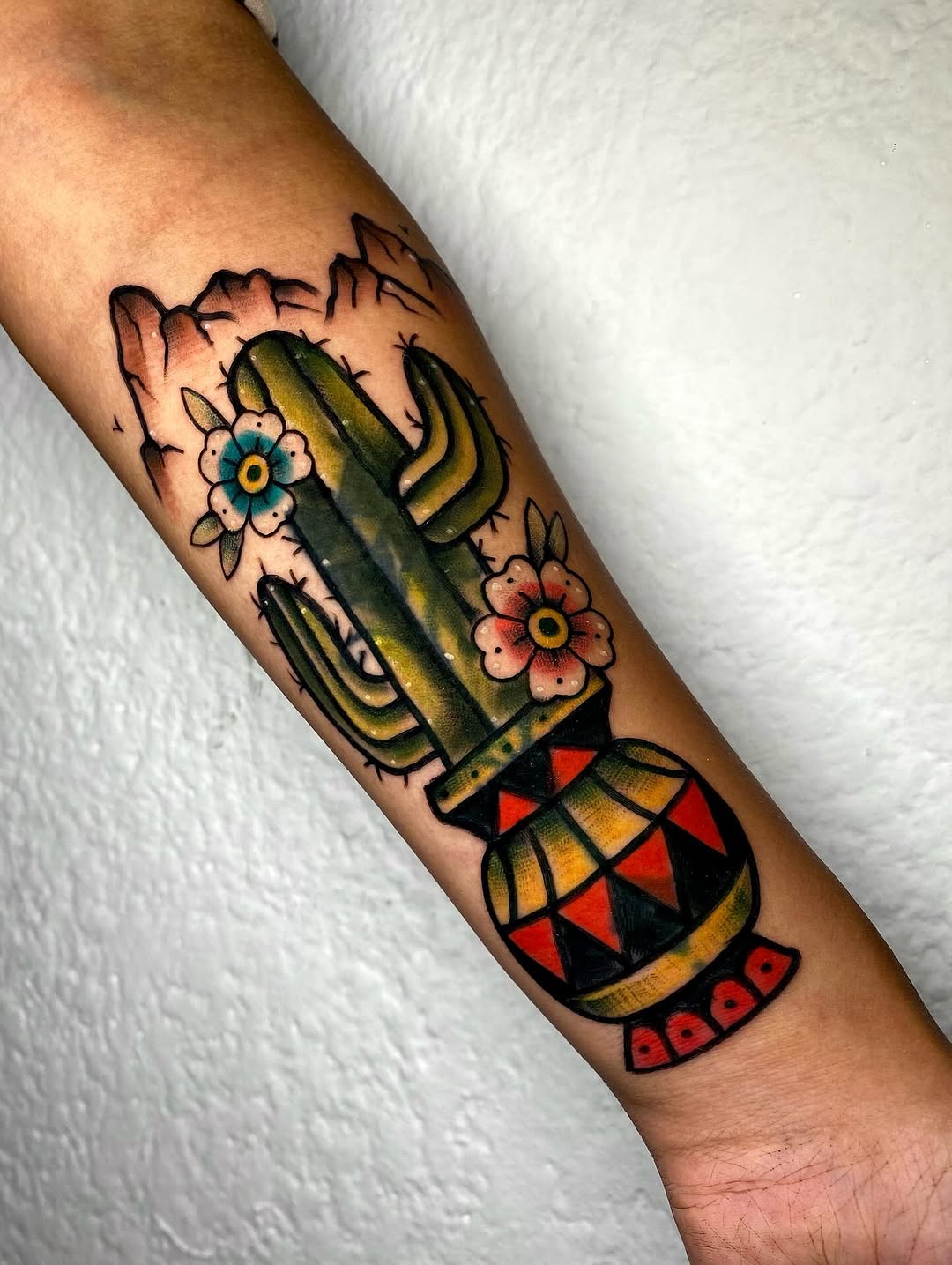 Vibrant cactus tattoo with floral elements