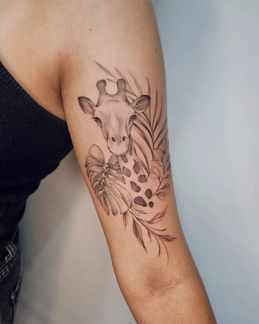 Elegant giraffe tattoo with lush tropical elements
