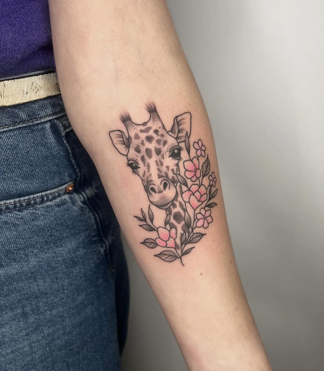 Charming giraffe tattoo with floral accents