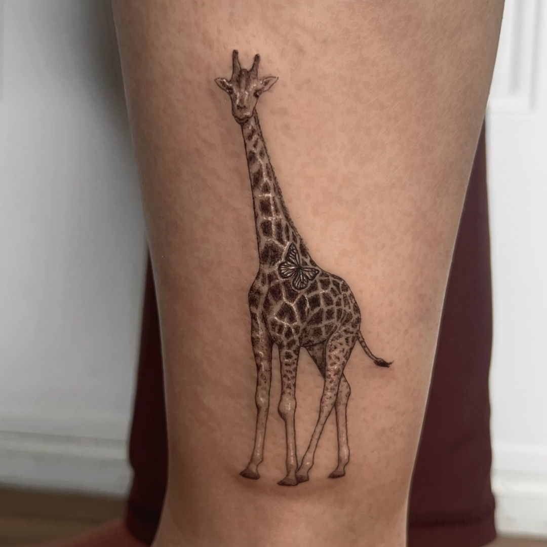 Intricate giraffe tattoo with butterfly embellishment