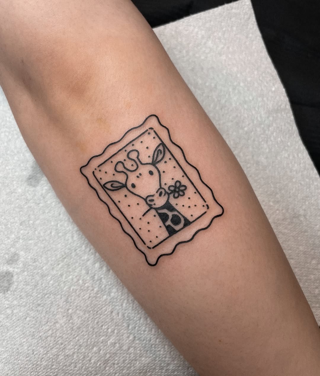 Charming framed giraffe tattoo in black outline