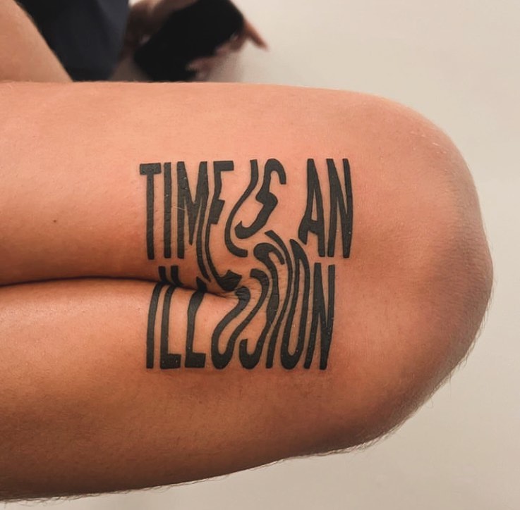 Stylized time illusion quote tattoo on knee