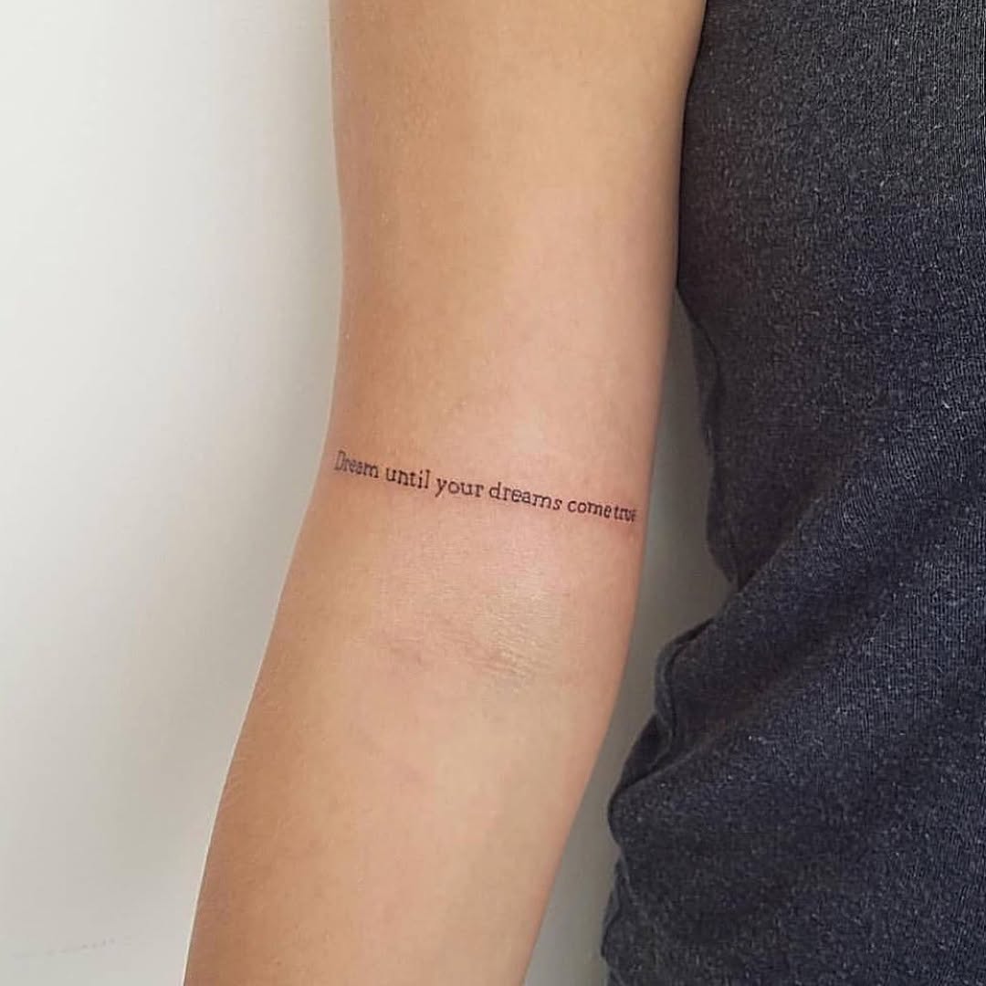 Inspirational quote tattoo on a forearm