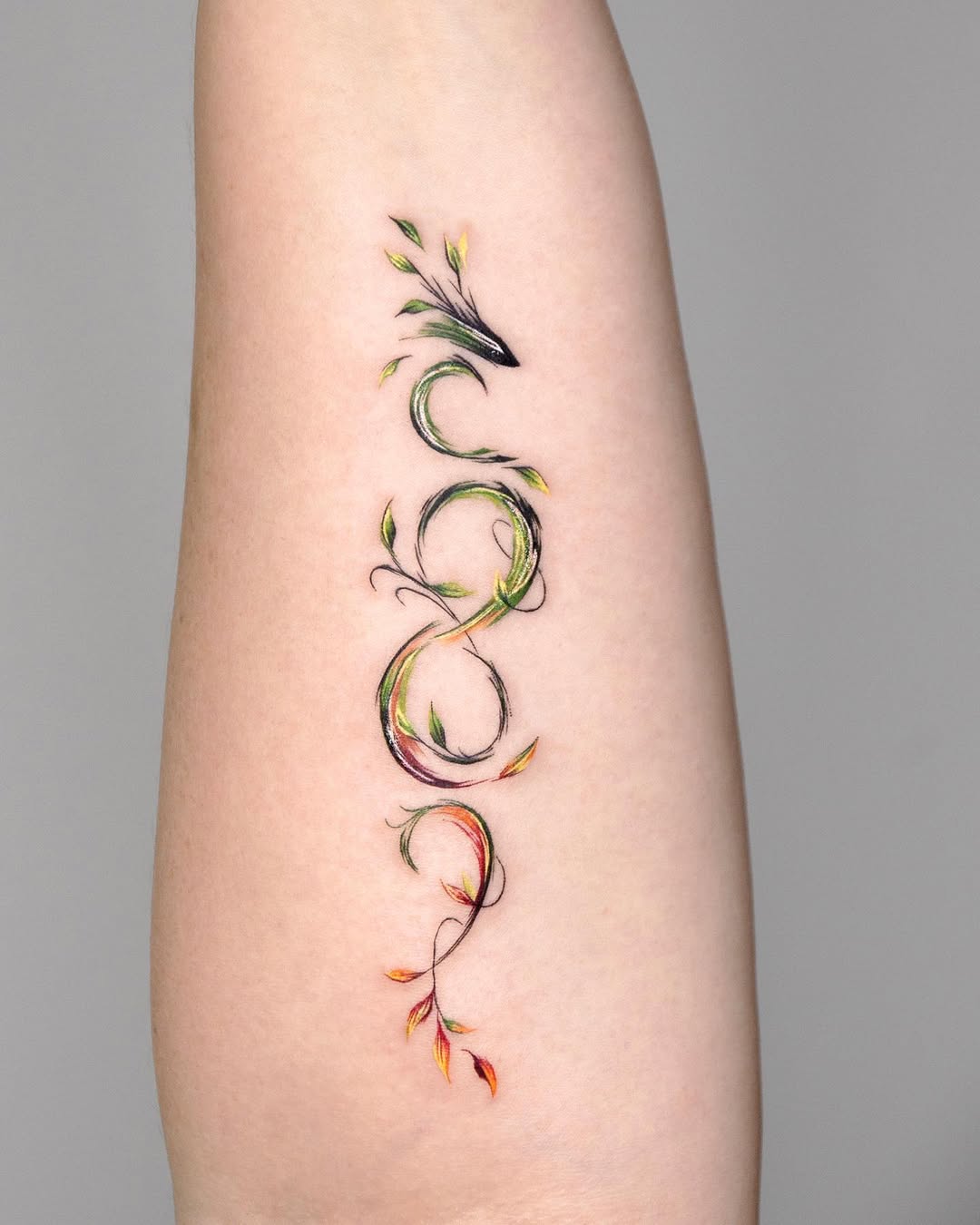 Elegant infinity tattoo with vibrant floral elements