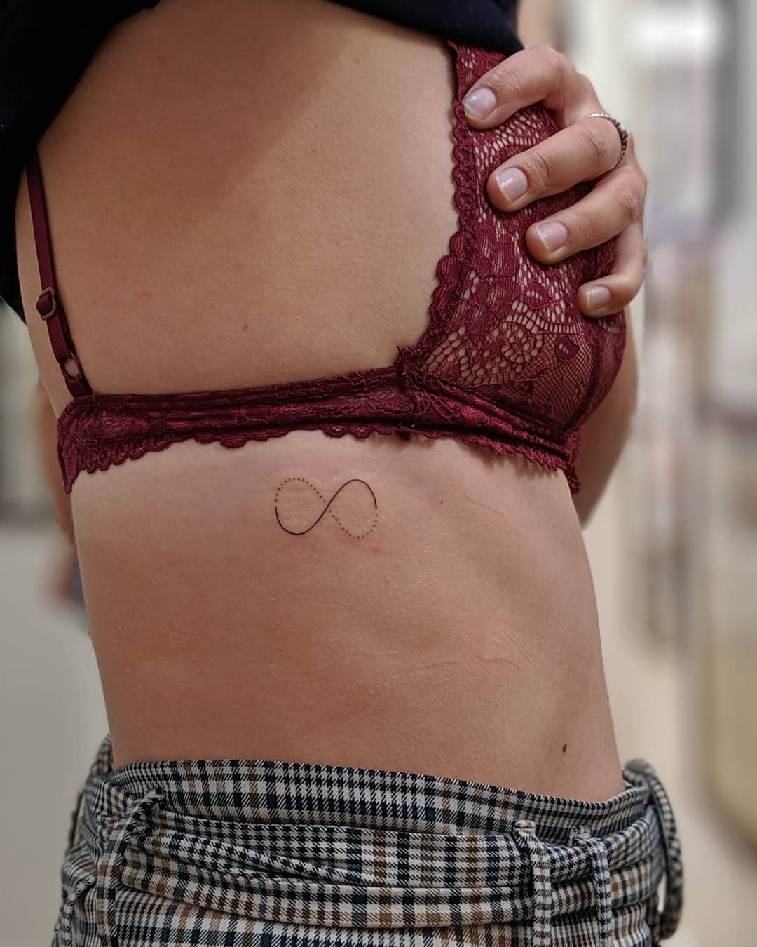 Elegant minimalist infinity tattoo on the side