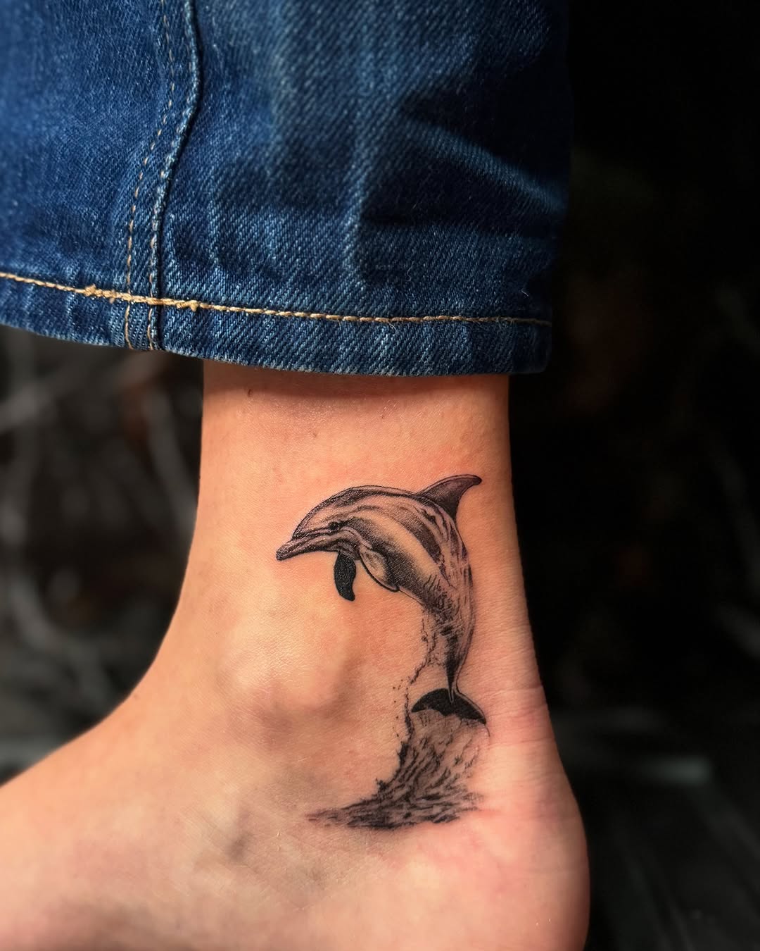 Elegant ankle dolphin tattoo design in motion