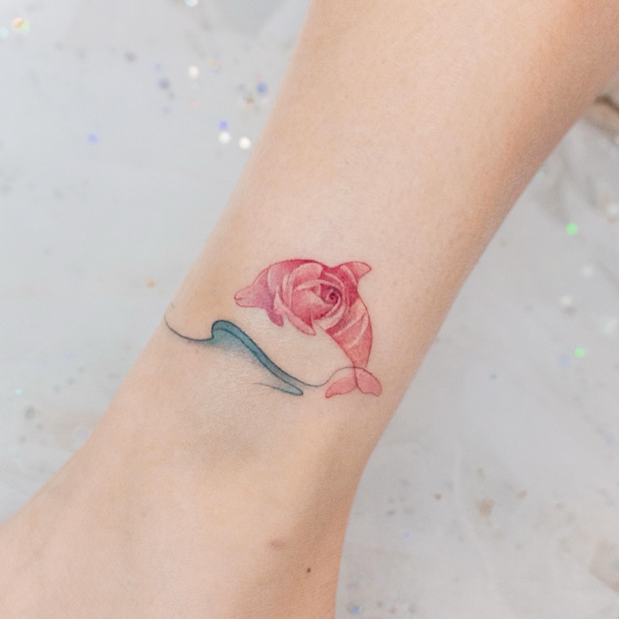Colorful dolphin tattoo with rose detail