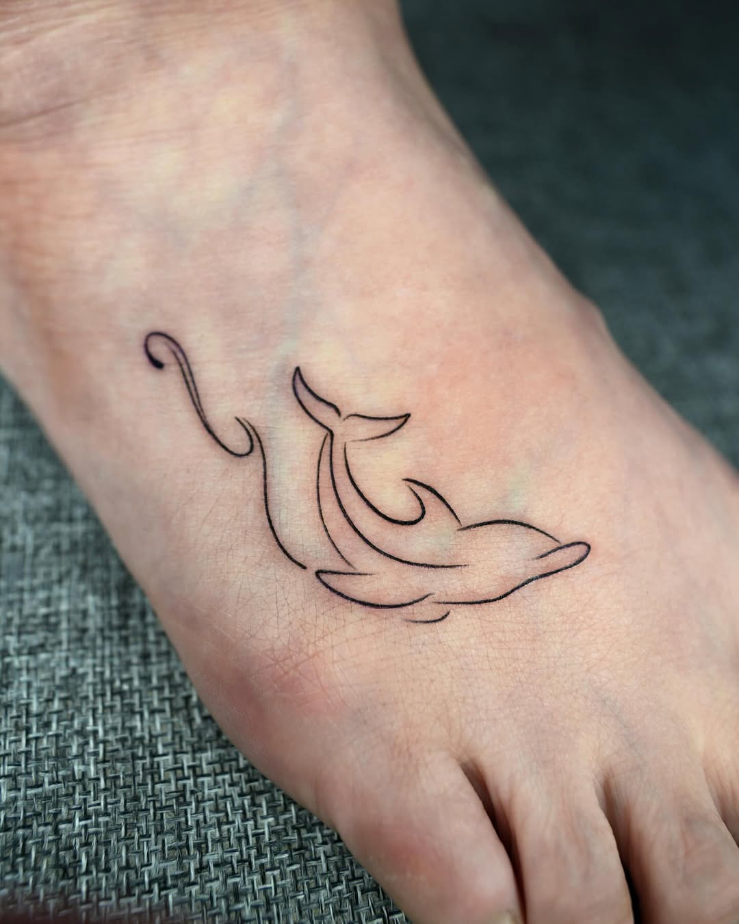 Minimalist Dolphin Tattoo on the Foot
