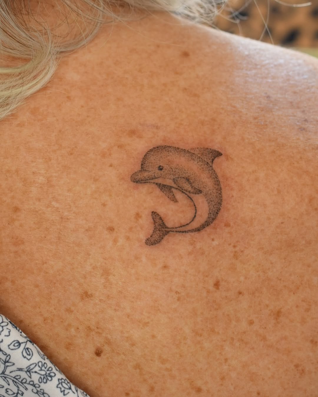 Charming dolphin tattoo on a woman's back