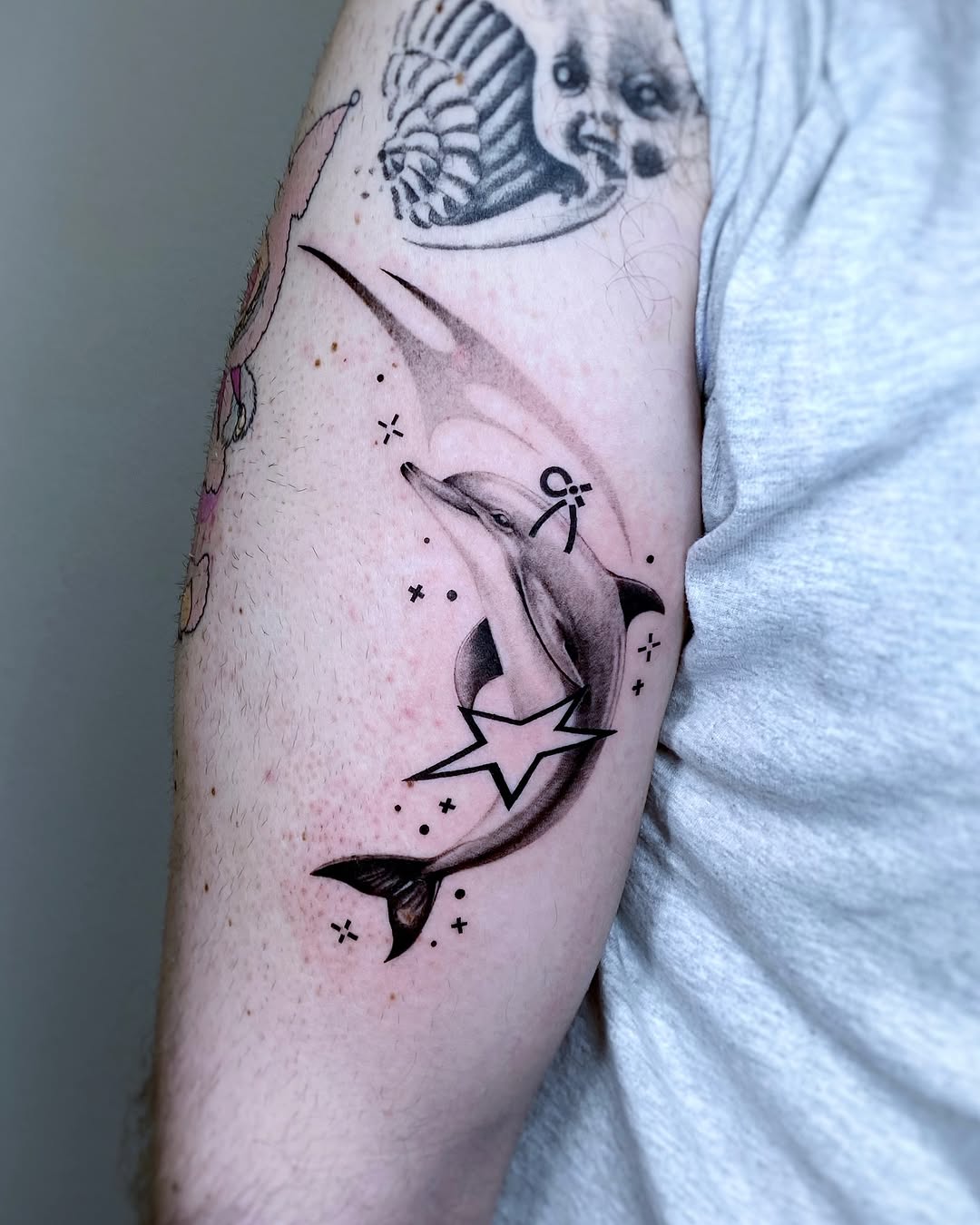 Whimsical dolphin tattoo with star accents