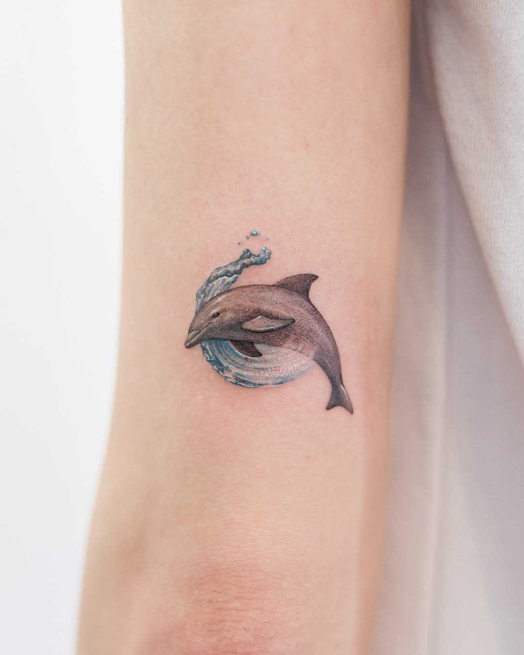 Stunning dolphin tattoo splashing through water