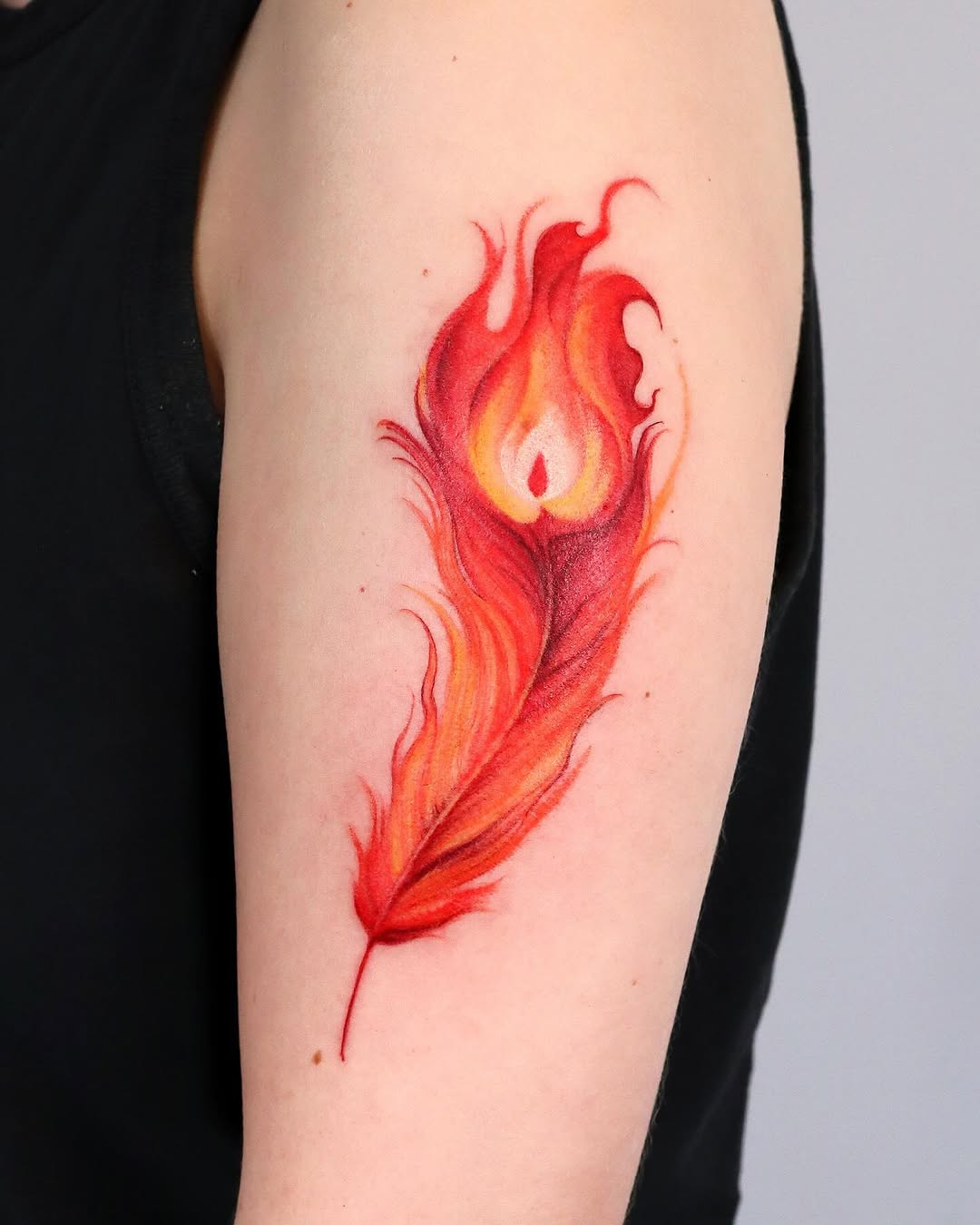 Vibrant feather tattoo with fiery aesthetics