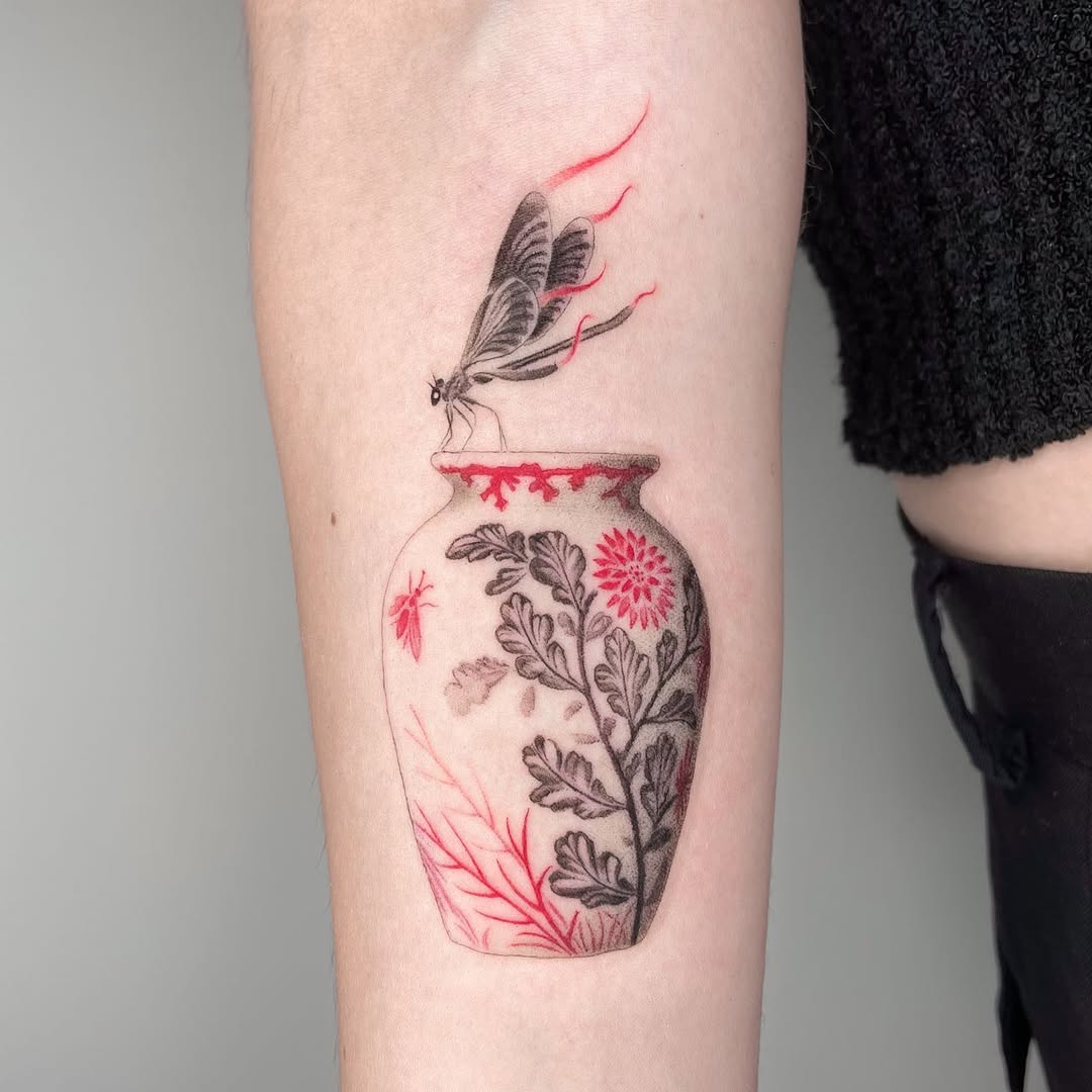 Intricate dragonfly tattoo with floral vase design