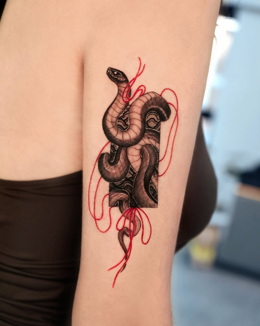 Striking snake tattoo with bold red accents