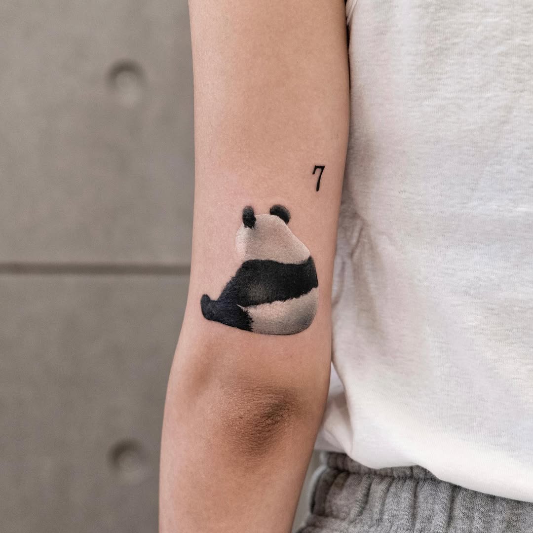 Charming minimalist panda tattoo design on arm