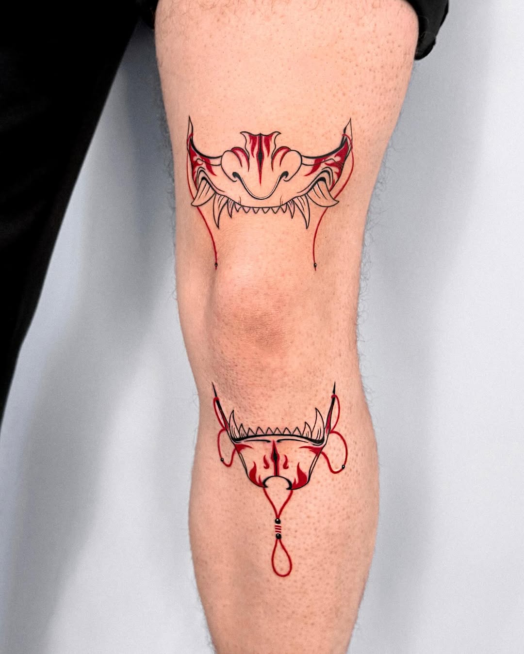 Striking red and black knee tattoo design