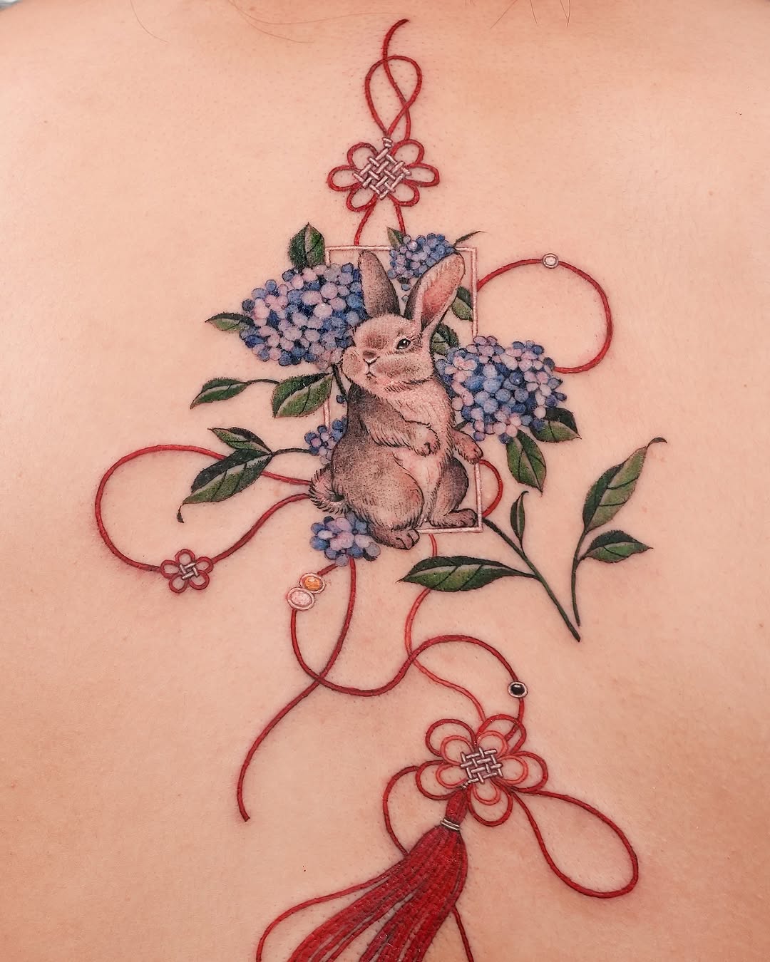 Charming rabbit tattoo amidst vibrant flowers