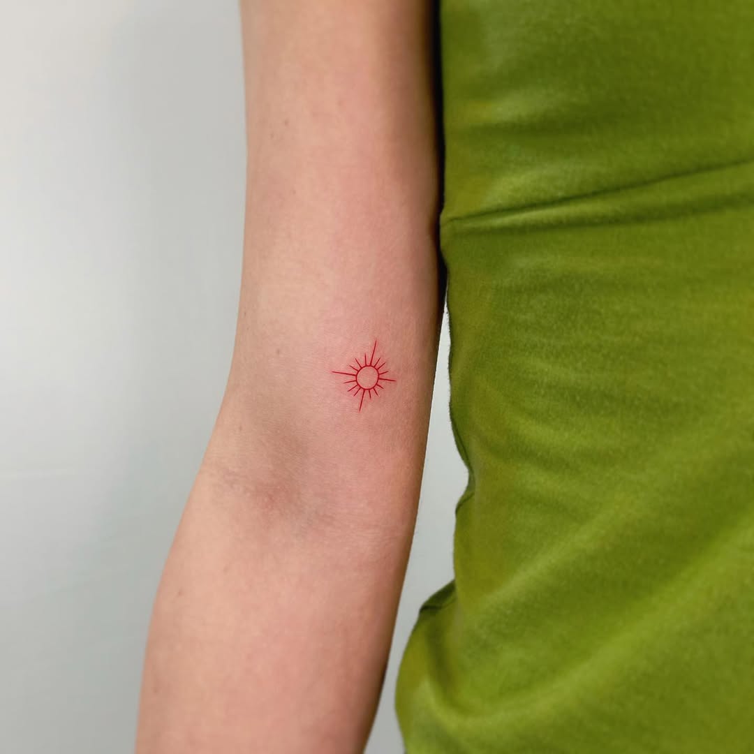 Minimalistic sun tattoo radiating vibrant energy
