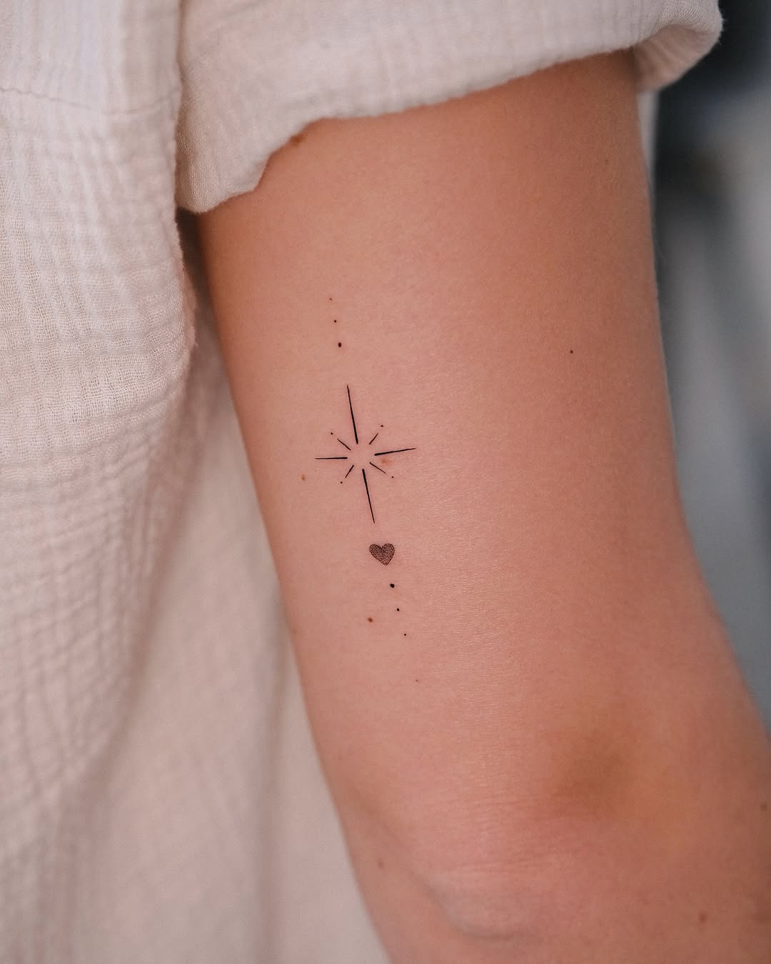 Elegant fine line star and heart tattoo