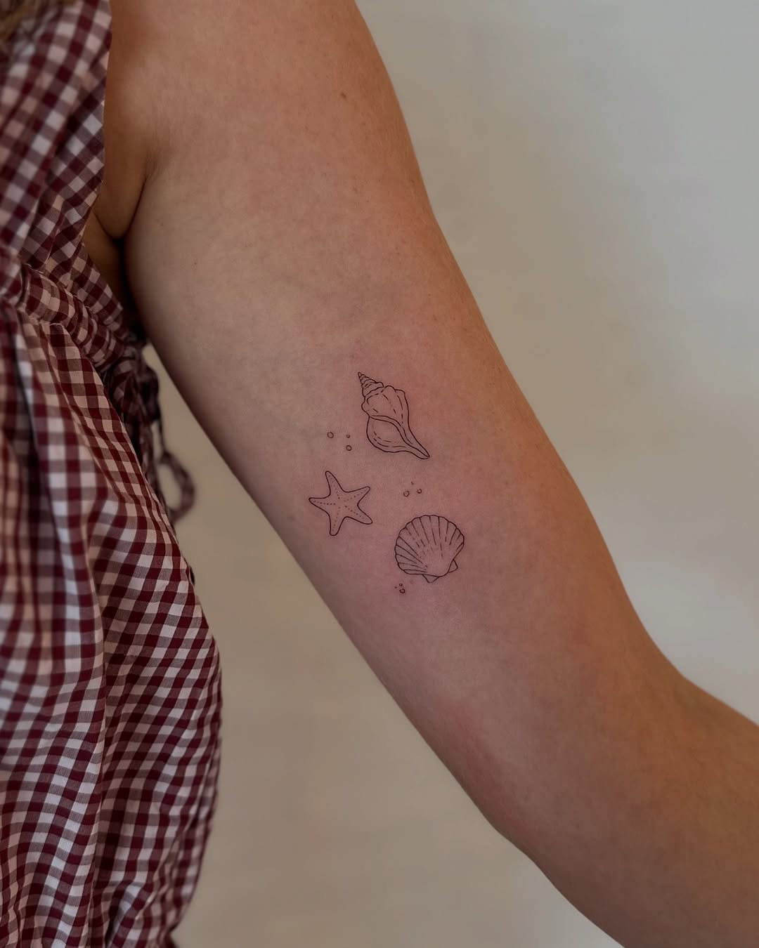 Delicate ocean-themed fine line tattoos