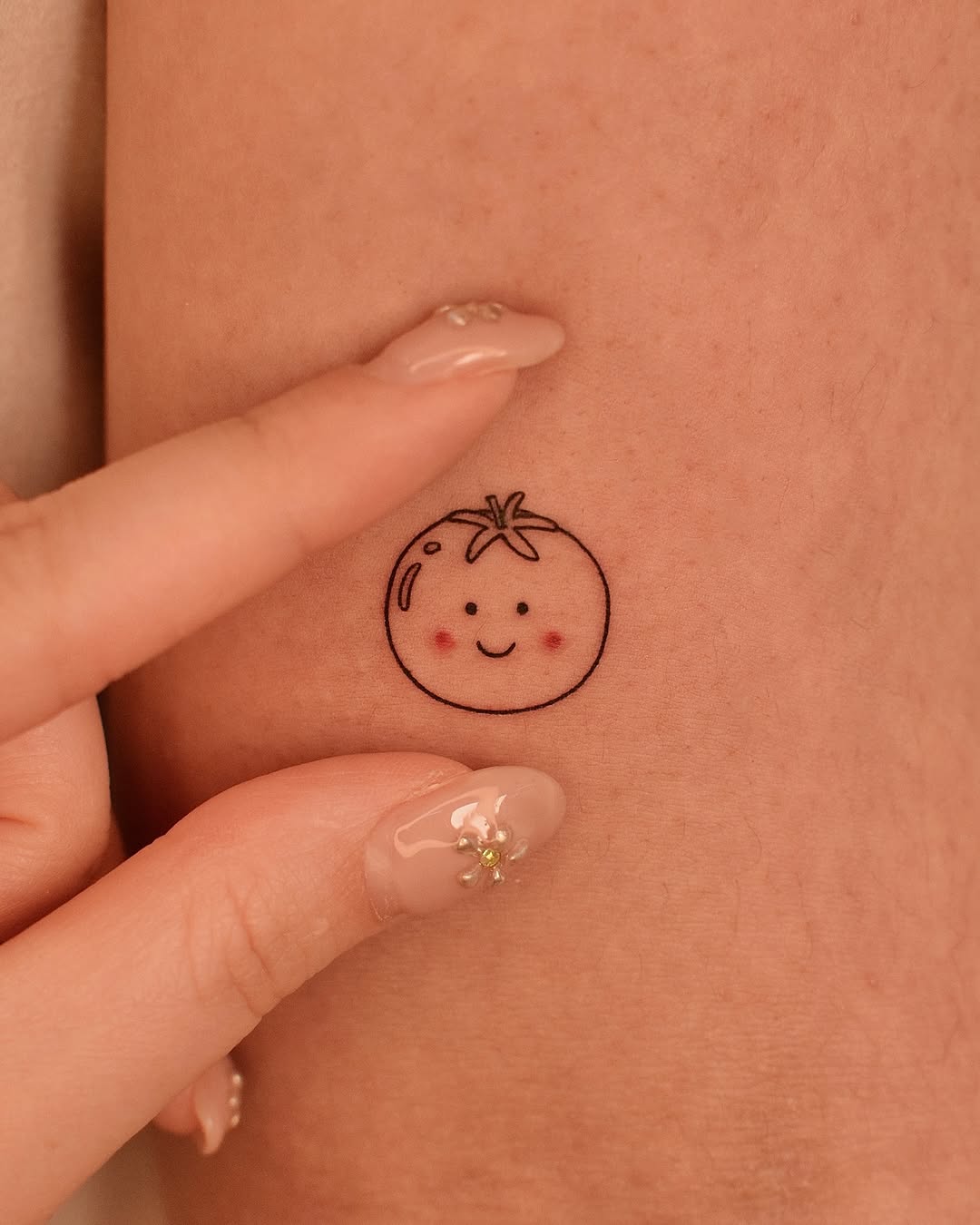 Cute tomato tattoo adds playful charm