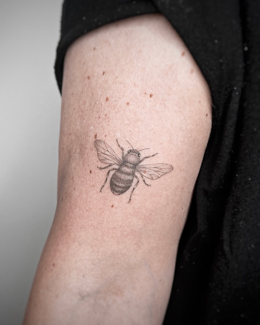Realistic bee tattoo on the arm