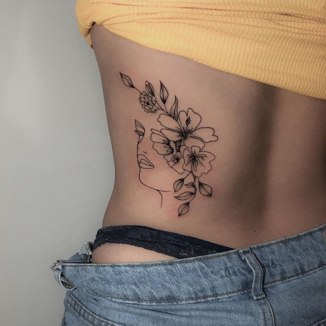 Elegant floral waist tattoo featuring a silhouette