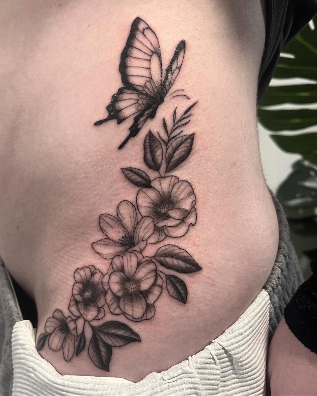 Elegant floral waist tattoo with butterfly accent