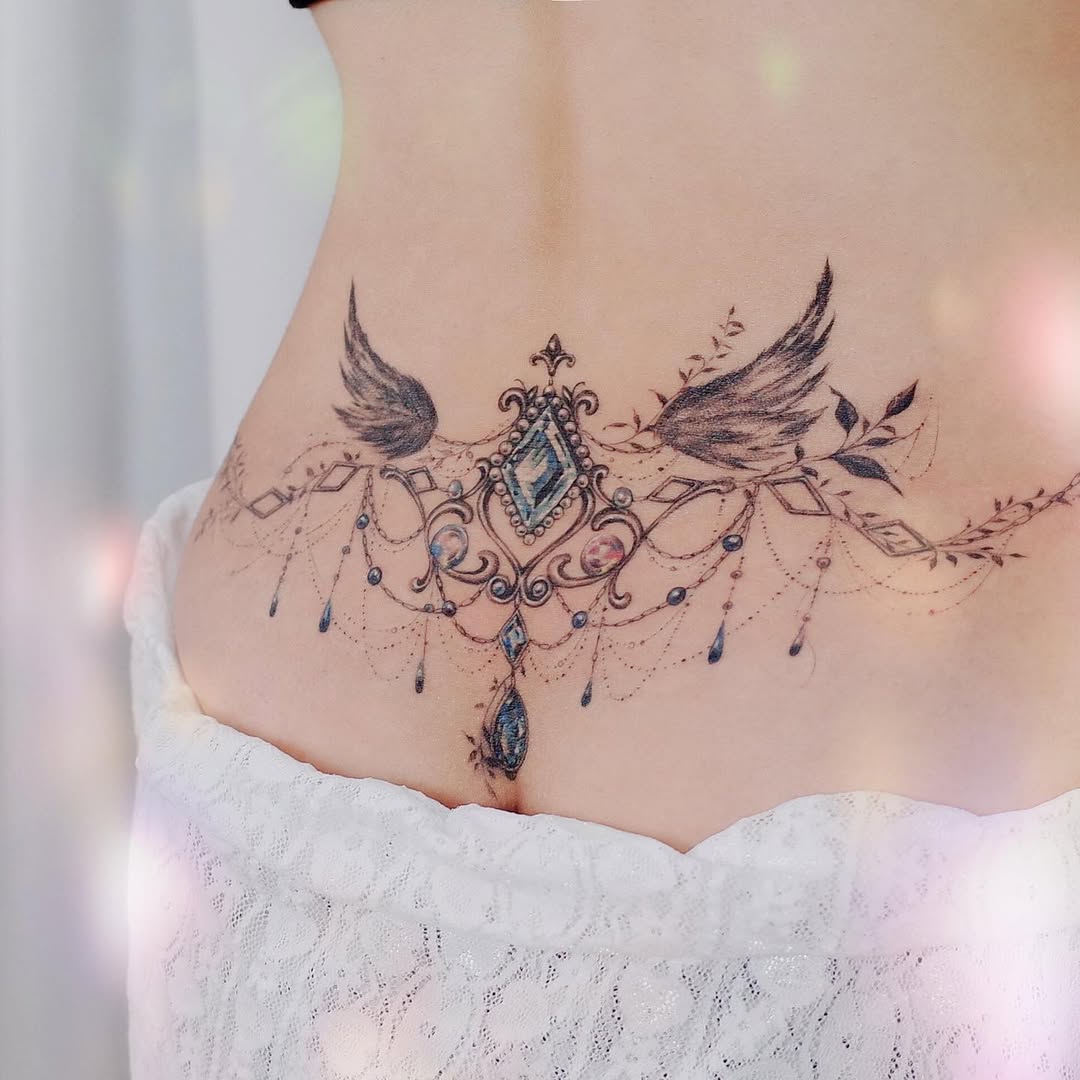 Elegant waist tattoo featuring wings and jewels