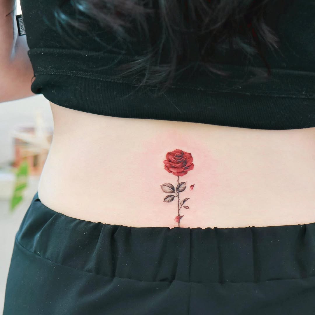Elegant rose tattoo gracing the lower back