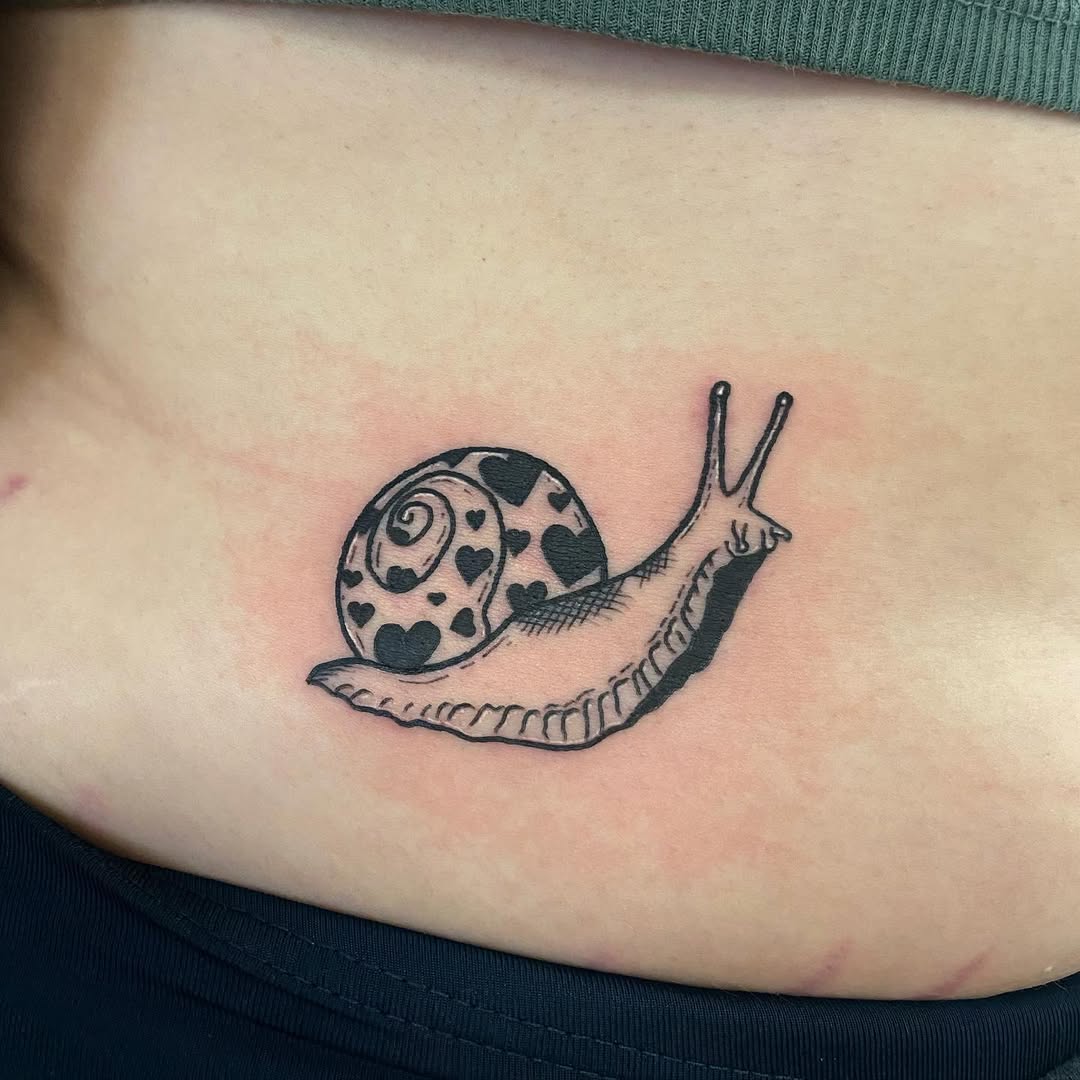 Charming snail tattoo with heart patterns
