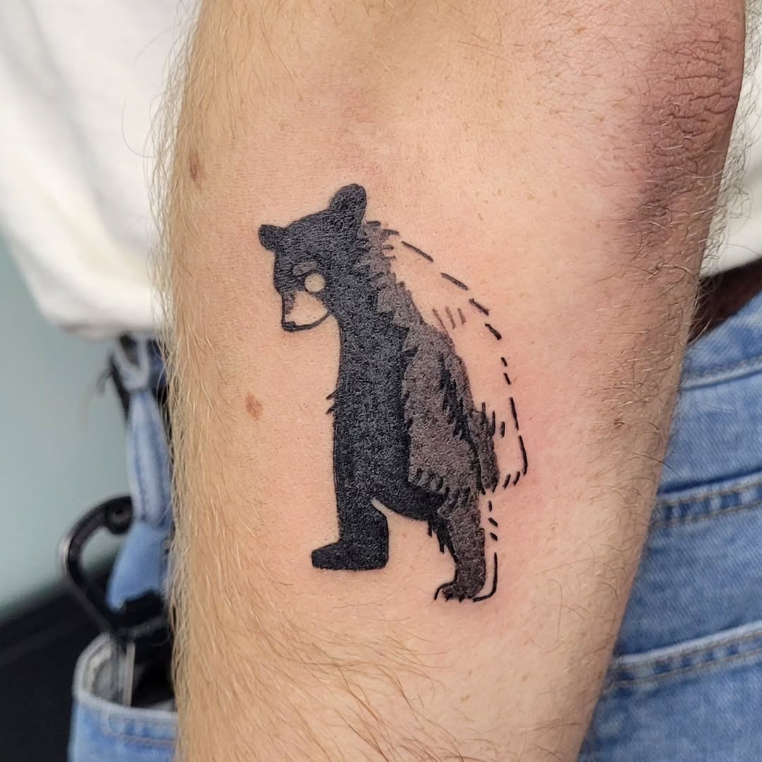 Stylish minimalist bear tattoo on forearm