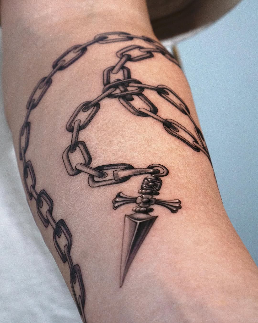 Intricate Chain and Dagger Forearm Tattoo Design